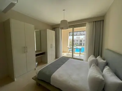 a bedroom with a bed and a view of a patio at Mangroovy Residence El Gouna - Grovin in Hurghada