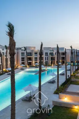 a large swimming pool with palm trees and buildings at Mangroovy Residence El Gouna - Grovin in Hurghada
