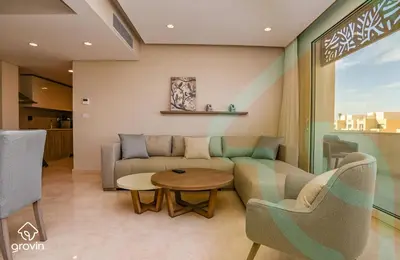a living room with a couch and a table and chairs at Mangroovy Residence El Gouna - Grovin in Hurghada