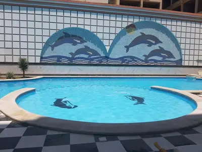 a mural of dolphins in the water in a swimming pool at apartman Sheraton plaza 419 in Hurghada