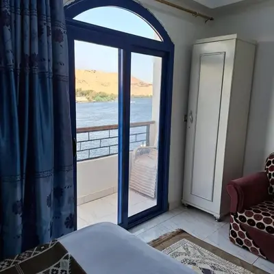 a bedroom with a large window with a view of the ocean at NOBATiA Guest House in Aswan