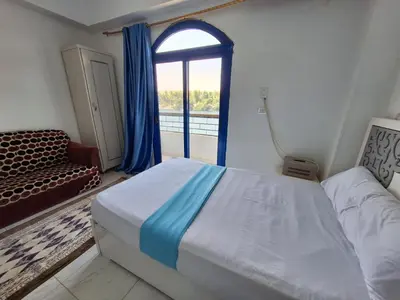 a small bedroom with a bed and a window at NOBATiA Guest House in Aswan