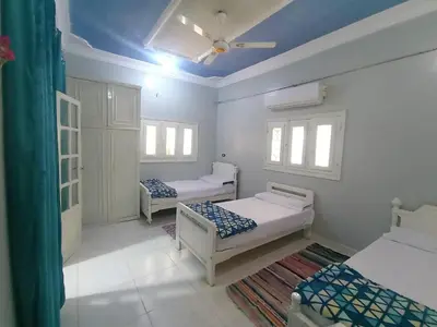 a bedroom with two beds and a blue ceiling at Winji Guest house in Aswan