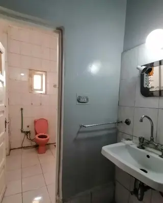 a bathroom with a red toilet and a sink at Winji Guest house in Aswan
