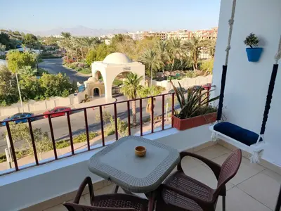 a balcony with a table and chairs and a view of a city at Studio Lotus compound near Touristic Mamsha in Hurghada
