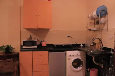 a kitchen with a washing machine and a microwave at Studio Lotus compound near Touristic Mamsha in Hurghada