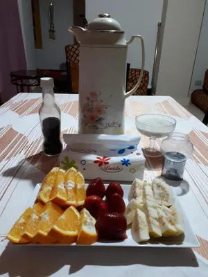 a plate of fruit on a table with a blender at Coral Paradise Villa in Safaga