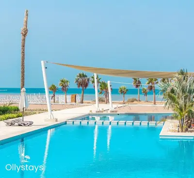 a swimming pool with palm trees and the beach at Ollystays Mangroovy Seaview 1BR Beach and Pool Free access in Hurghada