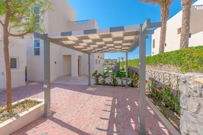 a pavilion outside of a building with trees and a wall at Joubal 3BR Villa Private Pool next to Marina in Hurghada