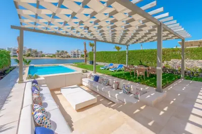 a white pergola over a patio with chairs and a pool at Joubal 3BR Villa Private Pool next to Marina in Hurghada