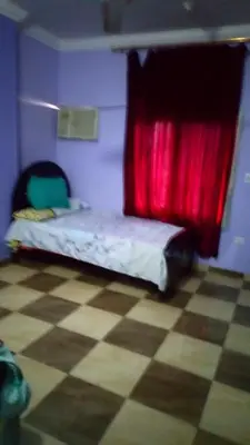 a bedroom with a bed with a red curtain at IKEA Flats in Hurghada
