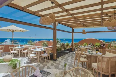 a restaurant with tables and chairs and a view of the ocean at AJIRA Boutique Hotel Hurghada Marina in Hurghada