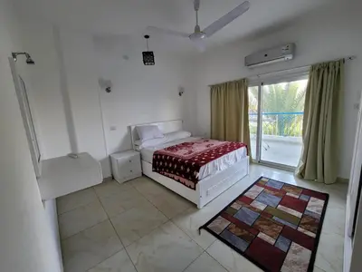 a bedroom with a bed and a large window at Hofni Palace Nile Niew in Luxor