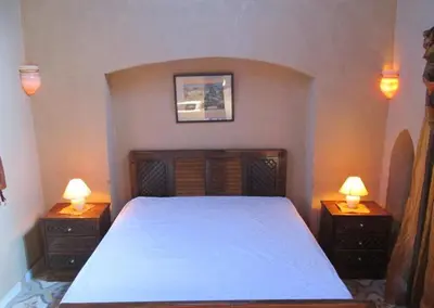 a bedroom with a large bed with two night stands at Scorpion House Luxor in Luxor