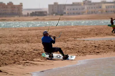 a man sitting on a surfboard on the beach at Studio beside El Gouna with good kite spot in 500 m in Hurghada