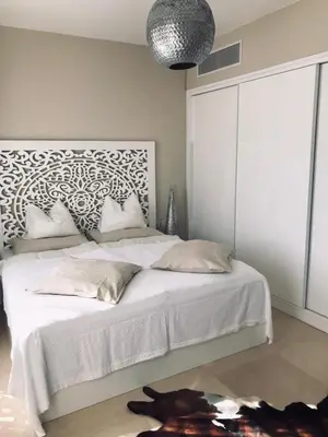 a bedroom with a large white bed with a headboard at Jutta Deluxe 2-Bedroom-Apartment Mangroovy-M7 El Gouna in Hurghada