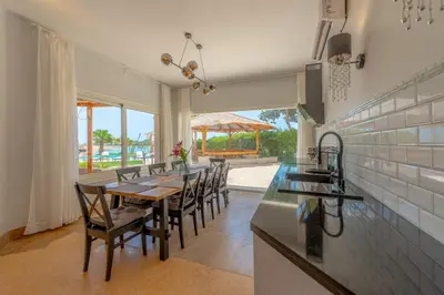 a kitchen and dining room with a table and chairs at 4 Bedroom Villa with Heated Pool, Jacuzzi & Lagoon View in Phase 4 in Hurghada