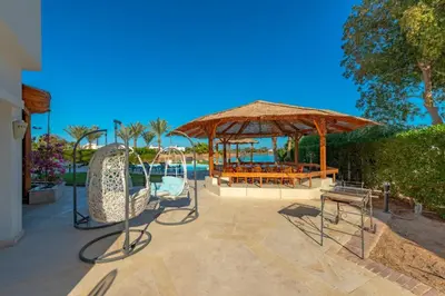 a patio with a table and chairs and a pavilion at 4 Bedroom Villa with Heated Pool, Jacuzzi & Lagoon View in Phase 4 in Hurghada