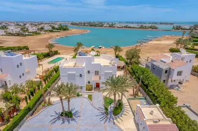 an aerial view of a white house and the ocean at 4 Bedroom Villa with Heated Pool, Jacuzzi & Lagoon View in Phase 4 in Hurghada