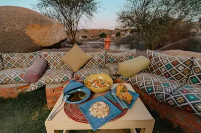 a table with a tray of food on a couch at Krouma Camp & Ecolodge in Aswan