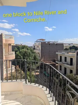 a balcony of a building with a sign that reads one block to nile river at Al Ramla Guest House in Luxor