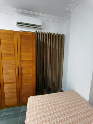 a bedroom with a bed and a dresser and a curtain at Rhein in Hurghada
