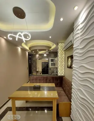 a dining room with a table and a kitchen at Rony's Ocean View Family Apartment in Hurghada