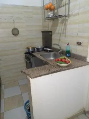 a kitchen with a sink and a bowl of fruit on a counter at Bob Marley Homestay in Hurghada