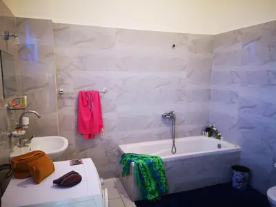 a white bathroom with a tub and a sink at Sinderella Private Pool Villa in Luxor