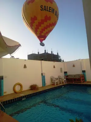 a hot air balloon flying over a swimming pool at Sinderella Private Pool Villa in Luxor