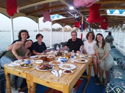 a group of people sitting around a table on a boat at Sinderella Private Pool Villa in Luxor