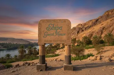 a sign in the middle of a desert with palm trees at Shipa Nubian Guest House in Aswan