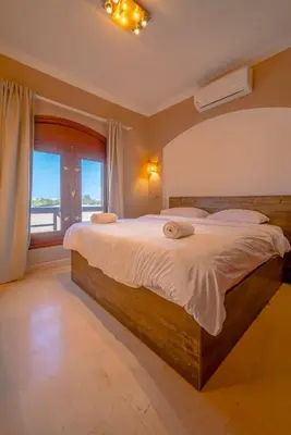 a bedroom with a large bed and a large window at Sabina Classy 1 BR Apartment Lagoon view & Pool El Gouna in Hurghada