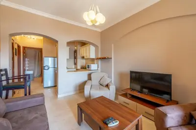 a living room with a television and a table at Sabina Classy 1 BR Apartment Lagoon view & Pool El Gouna in Hurghada