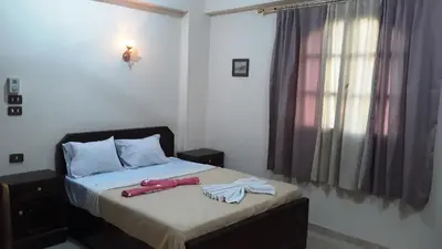 a bedroom with a bed with a towel on it at Moonlight Home in Luxor