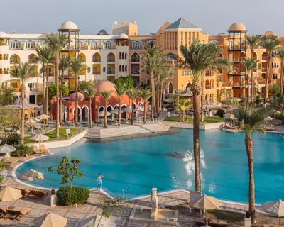 an overhead view of a resort pool with palm trees and buildings at The Grand Resort in Hurghada