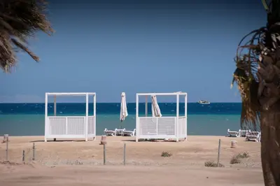 a group of chairs and umbrellas on a beach at Earthy & Tranquil 1 BDR Mangroovy Free Pool & Beach Access in Hurghada