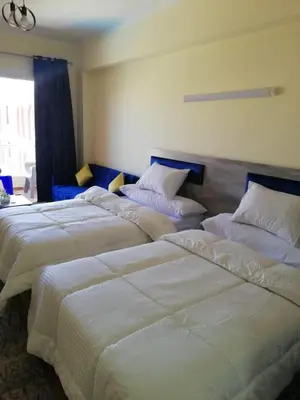 two beds in a hotel room with white sheets at florenza khamsin studio in hurghada pool view in Hurghada