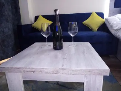 a bottle of wine and two wine glasses on a table at florenza khamsin studio in hurghada pool view in Hurghada
