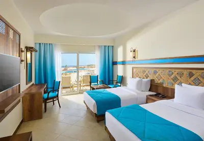 a hotel room with two beds and a television at Lazuli Hotel, Marsa Alam in Quseir