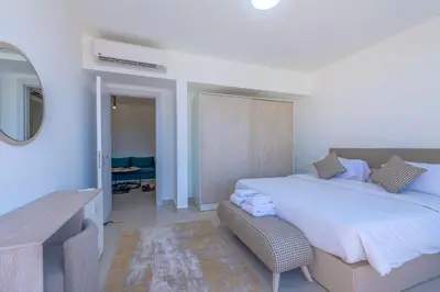 a bedroom with a large bed and a mirror at VESTA - El Gouna Residence in Hurghada
