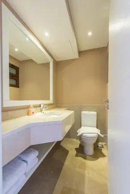a bathroom with a sink and a toilet and a mirror at VESTA - El Gouna Residence in Hurghada