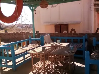 a wooden table and chairs on a patio at Sea Waves Hostel not for Egyptian in Hurghada
