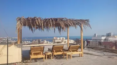 a group of chairs sitting under a straw roof at The LOTUS in Hurghada