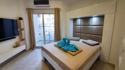 a bedroom with a bed and a flat screen tv at Aqua Palms Studio A210 in Hurghada