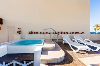 a swimming pool with chairs and a hot tub at Sataya Resort Marsa Alam in Marsa Alam City