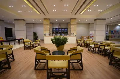 a lobby with chairs and a table and a bar at Sataya Resort Marsa Alam in Marsa Alam City