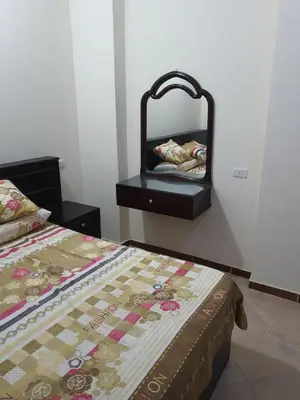 a bedroom with a bed and a dresser with a mirror at Abeer Suites in Hurghada