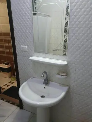 a white sink in a bathroom with a mirror at Abeer Suites in Hurghada