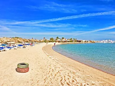 a beach with a basket on the sand and the water at The Touristic Promenade Apartment in Hurghada